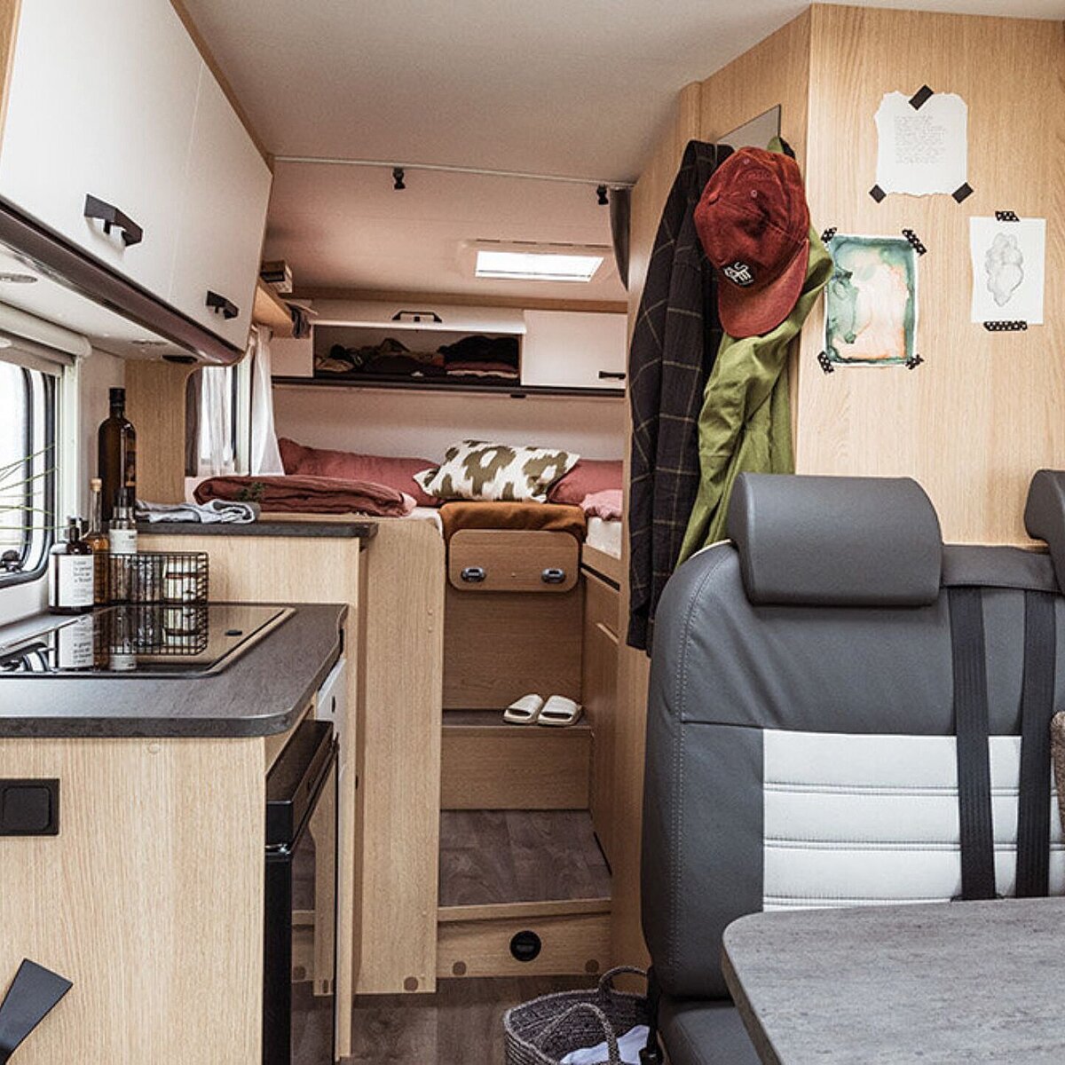 Der Innenraum eines Wohmobils mit Blick zur Sitzecke, Küche und Schlafbereich