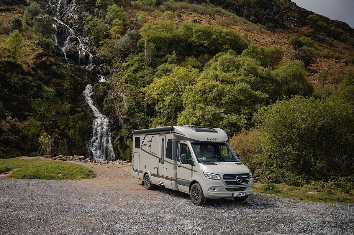 Ein Wohnmobil vor einem Wasserfall.