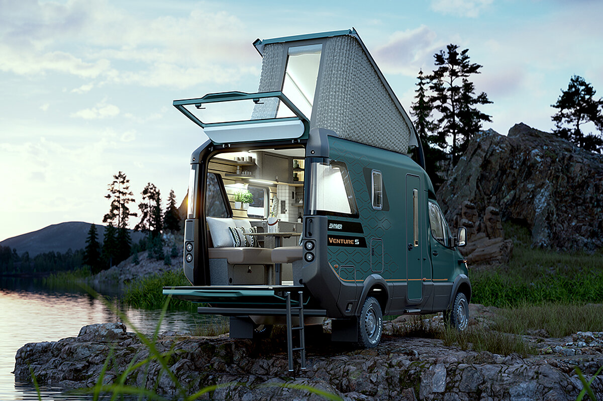 Ein Camper Van mit Hubdach und offenem Kofferraum parkt neben einem See im Abendlicht.