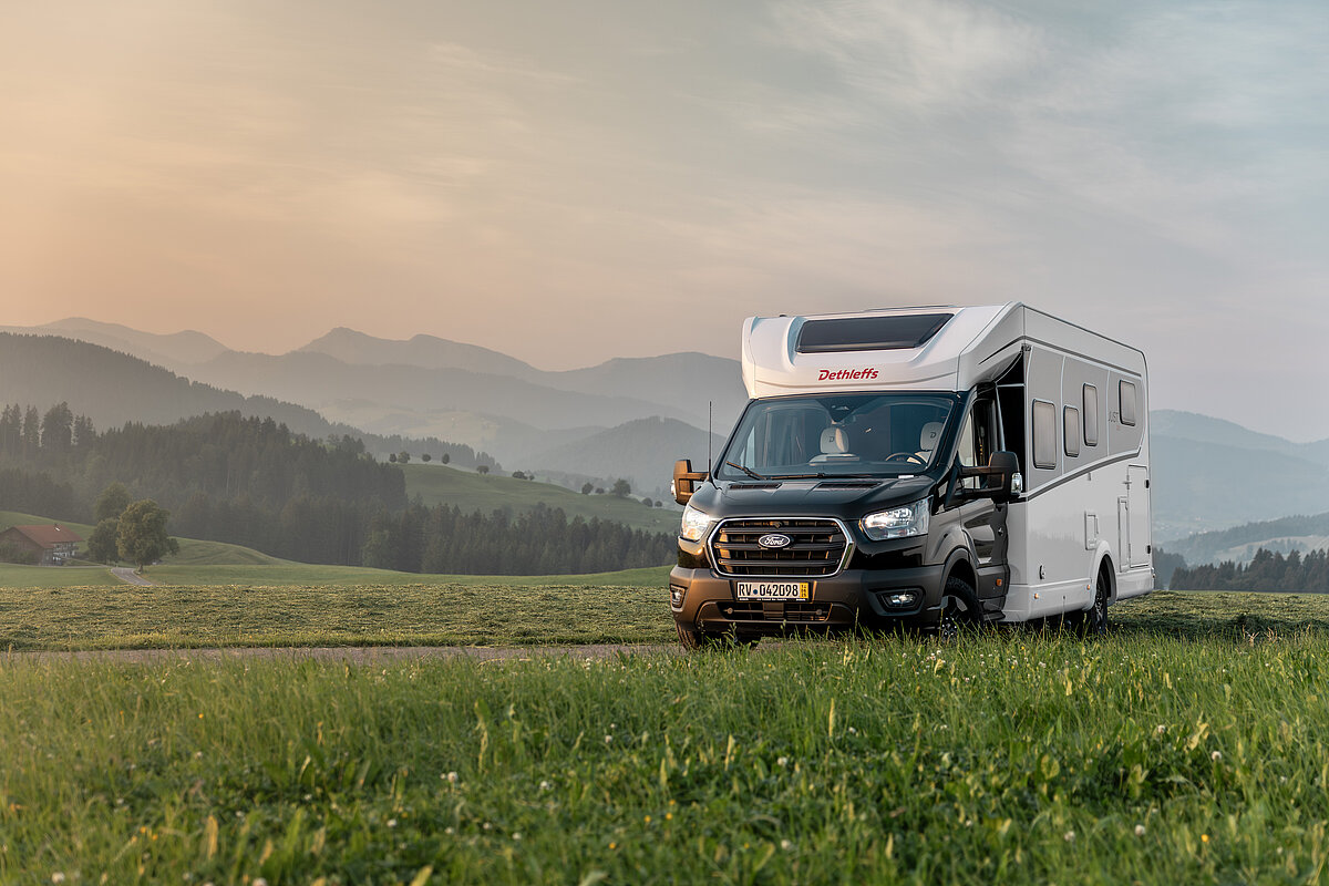 Ein teilintegriertes Wohnmobil von Dethleffs auf einer Wiese.