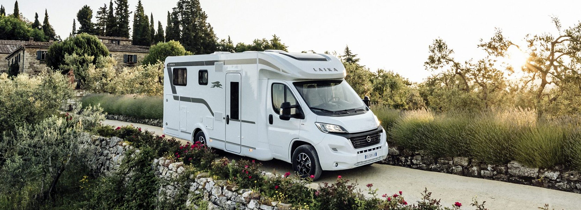 Ein Wohnmobil von Laika fährt eine schmale Bergstraße entlang.